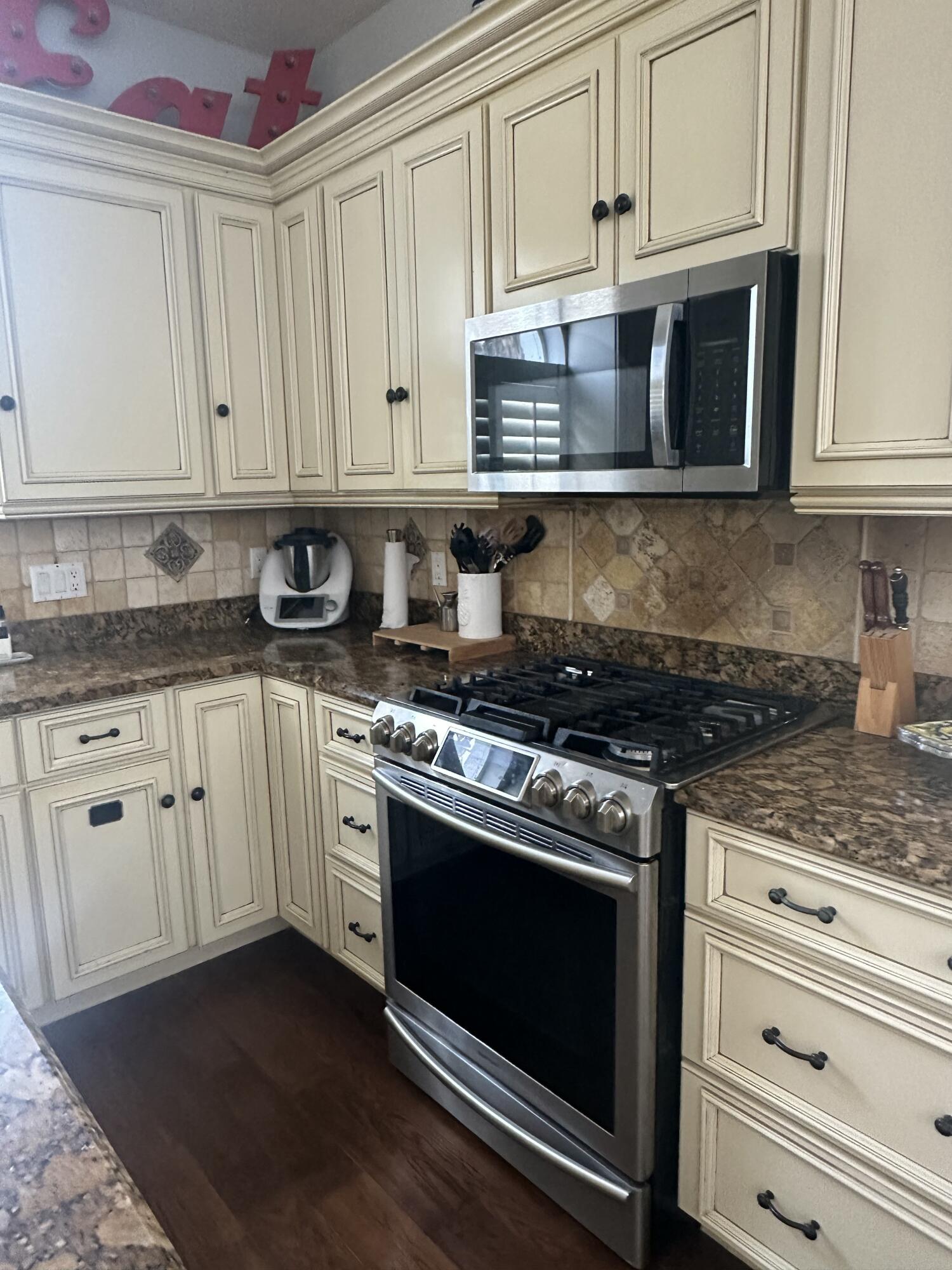 115 Spoonbill Court Jupiter, FL 33458 - Photo 12 of 52 a kitchen with granite countertop white cabinets and appliances