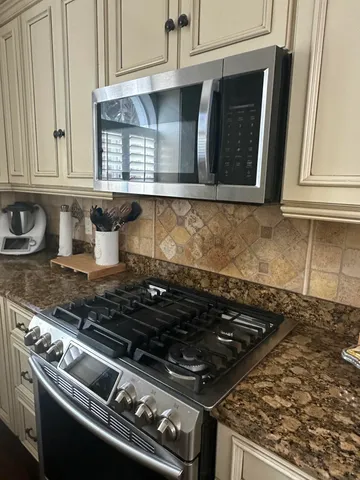 a stove top oven sitting inside of a kitchen