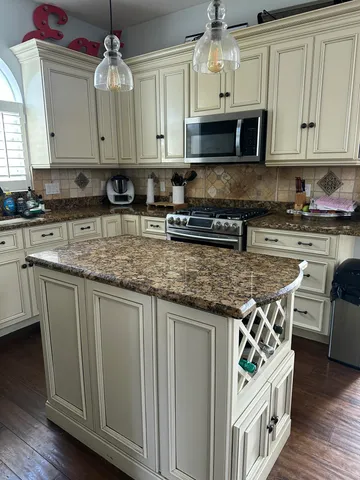 a kitchen with stainless steel appliances granite countertop a stove a sink and a microwave