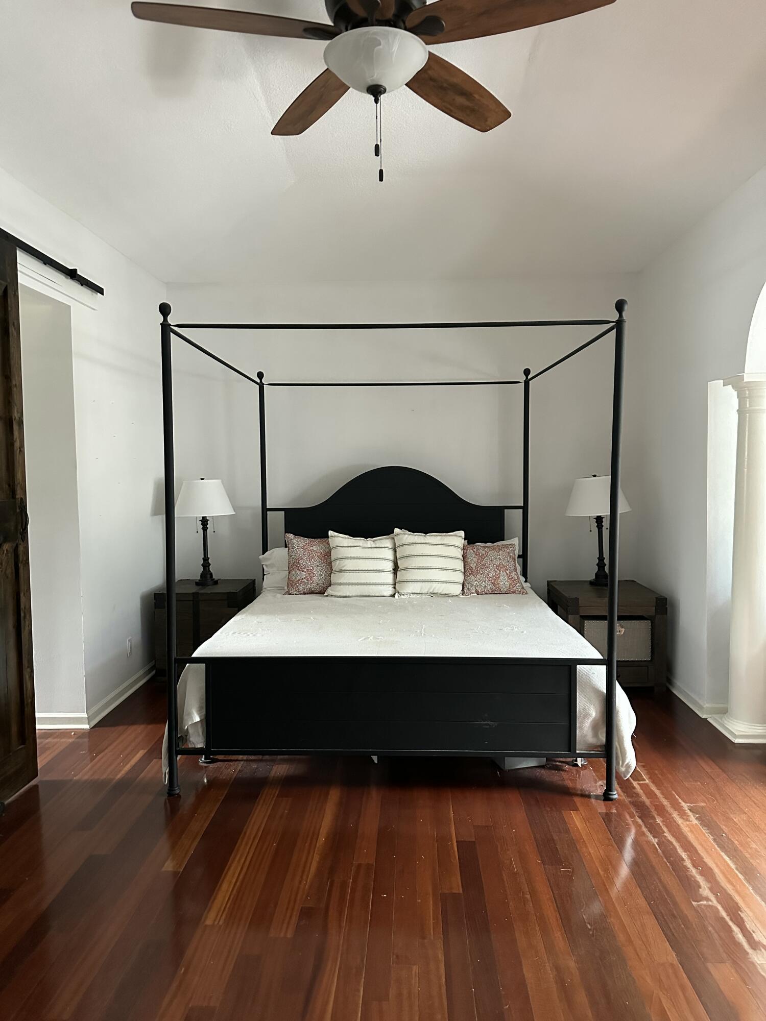 115 Spoonbill Court Jupiter, FL 33458 - Photo 20 of 52 a bedroom with a bed and wooden floor