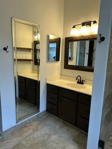 a bathroom with double vanity sink and a mirror