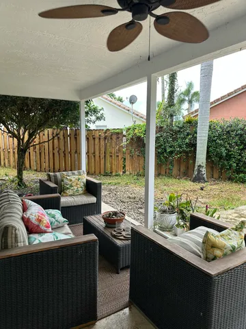 a view of a yard with potted plants and a large tree