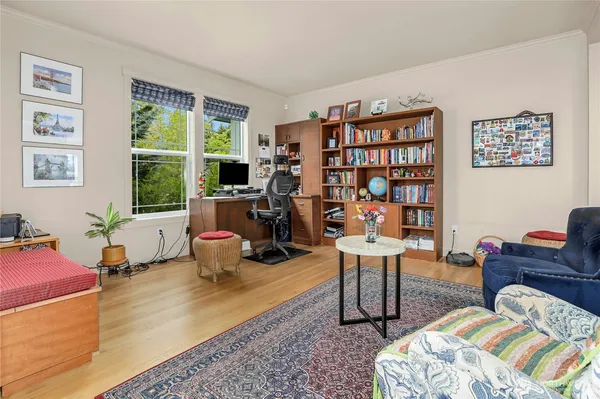 a bedroom with bed a large window and book shelf