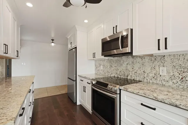 a kitchen with granite countertop a sink and stainless steel appliances