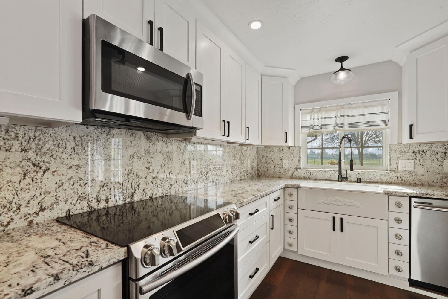 1525 West Vine Street Lodi, CA 95242 - Photo 12 of 36 a kitchen with stainless steel appliances granite countertop a stove a sink and a microwave