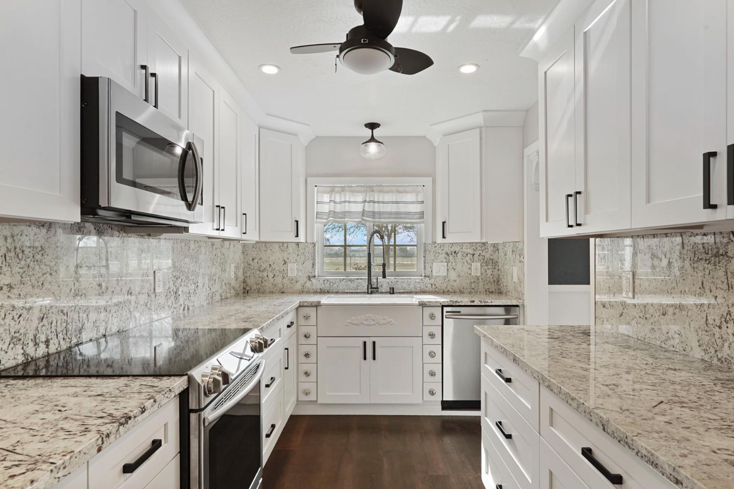 1525 West Vine Street Lodi, CA 95242 - Photo 13 of 36 a kitchen with stainless steel appliances granite countertop a sink and dishwasher a stove top oven with wooden floor