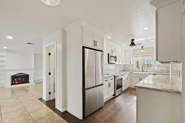 a kitchen with stainless steel appliances granite countertop a refrigerator and a sink