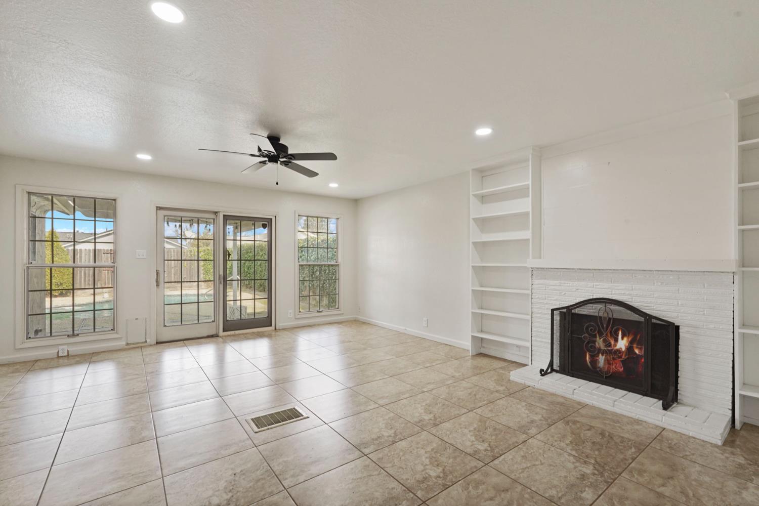 1525 West Vine Street Lodi, CA 95242 - Photo 17 of 36 a view of an empty room with a fireplace and a window