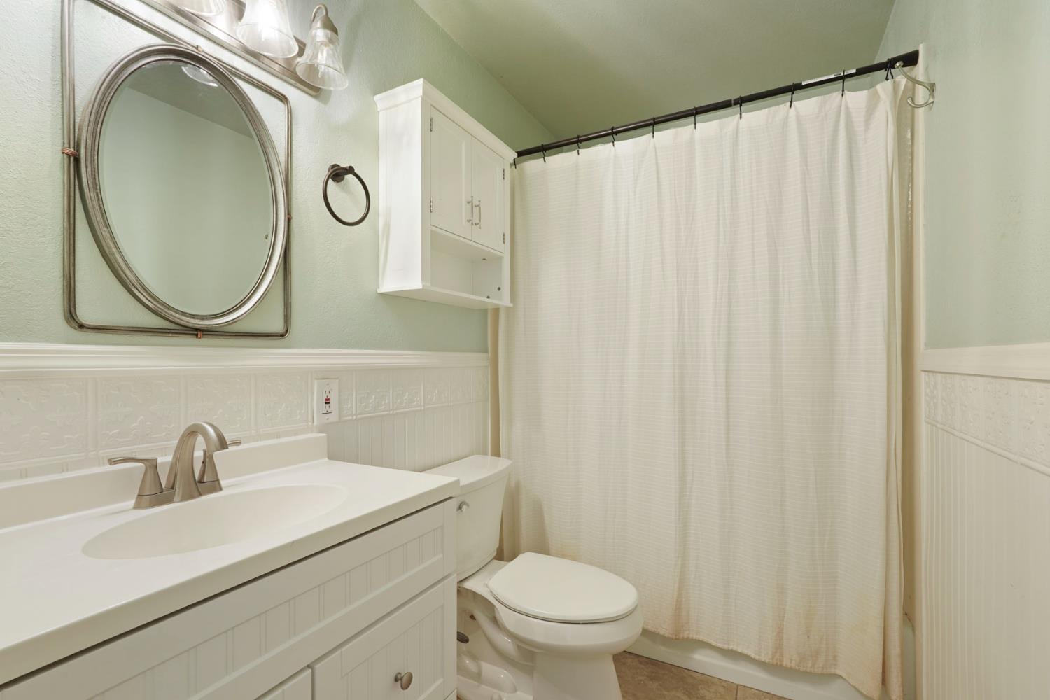 1525 West Vine Street Lodi, CA 95242 - Photo 21 of 36 a bathroom with a sink a mirror a toilet and a sink
