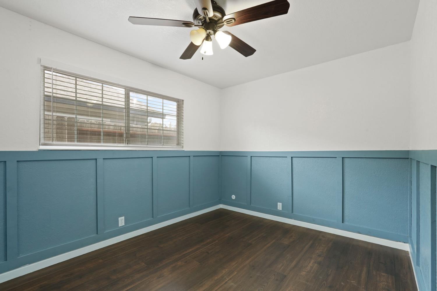1525 West Vine Street Lodi, CA 95242 - Photo 24 of 36 an empty room with wooden floor fan and windows
