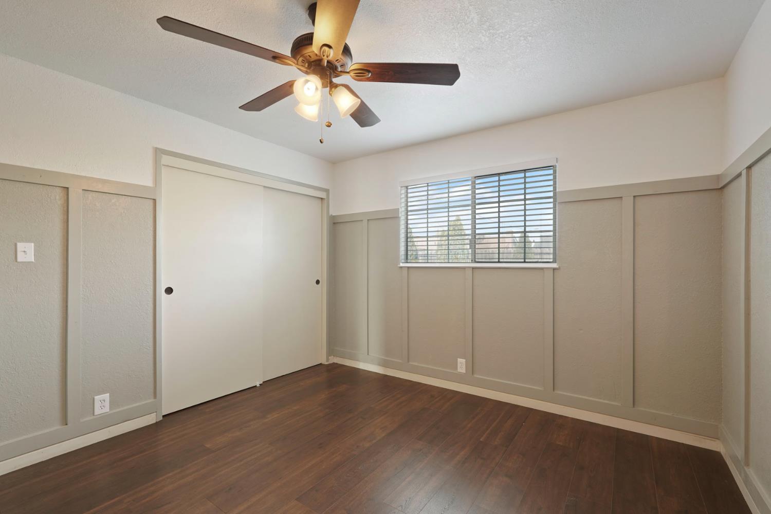 1525 West Vine Street Lodi, CA 95242 - Photo 27 of 36 an empty room with wooden floor fan and windows