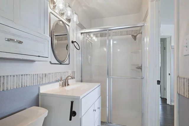 a bathroom with a sink a toilet and shower