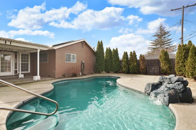 a view of a house with backyard and a sitting area
