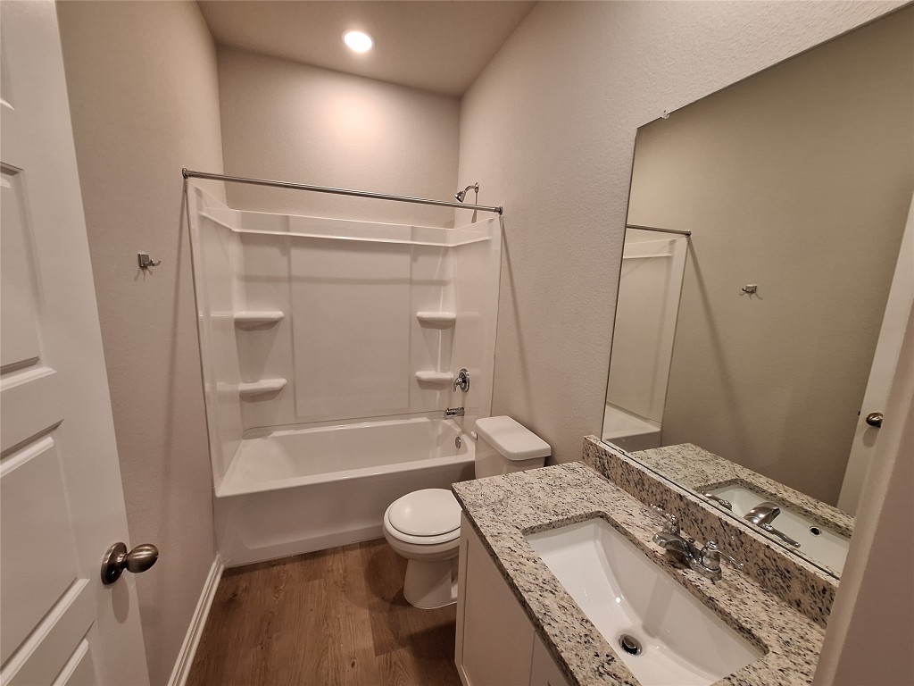 104 Gunner Road, Unit B Buda, TX 78610 - Photo 12 of 22 a bathroom with a granite countertop sink toilet and shower
