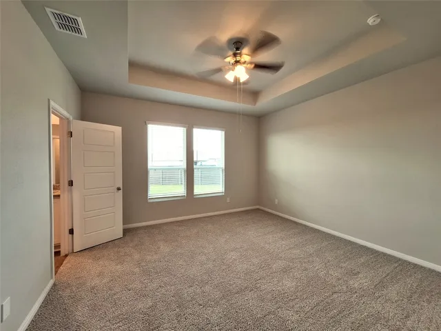 a view of an empty room with a chandelier fan