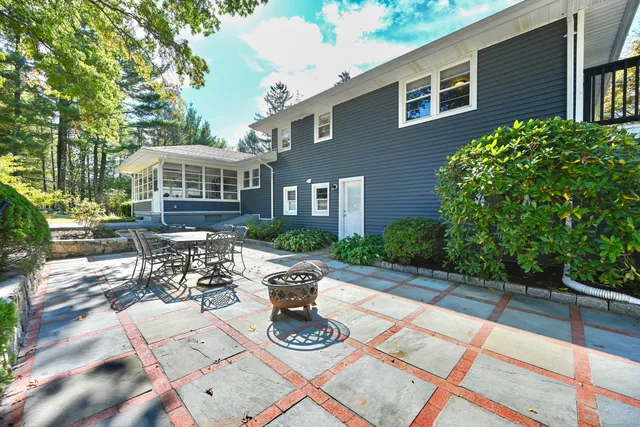 a view of a patio with table and chairs potted plants with wooden floor and fence