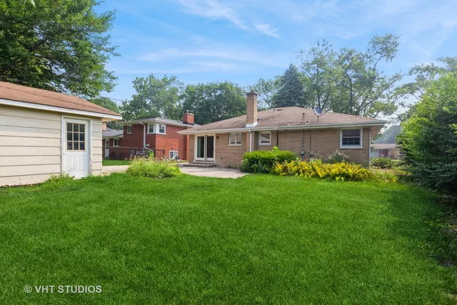 a front view of a house with a garden and trees