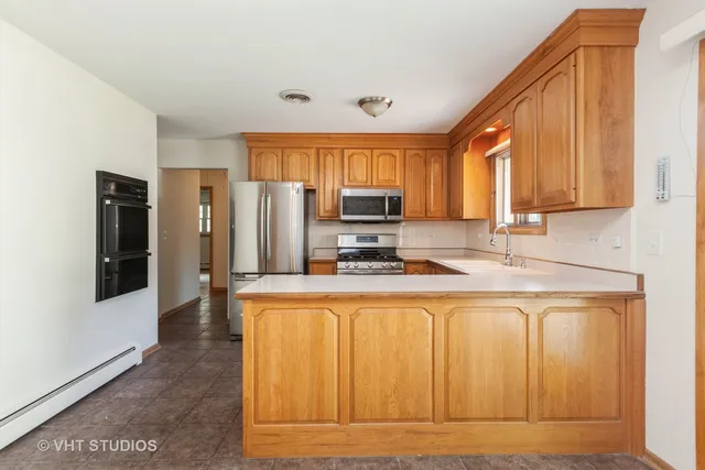 a kitchen with stainless steel appliances granite countertop a refrigerator a stove top oven a sink and dishwasher