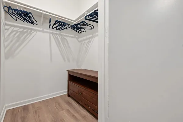 a view of walk in closet with clothes