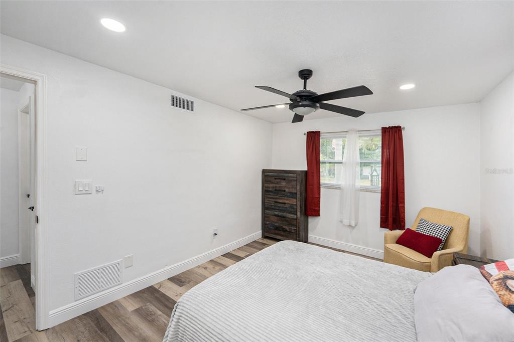 1806 North Keene Road Clearwater, FL 33755 - Photo 18 of 35 a bedroom with a bed and a chandelier