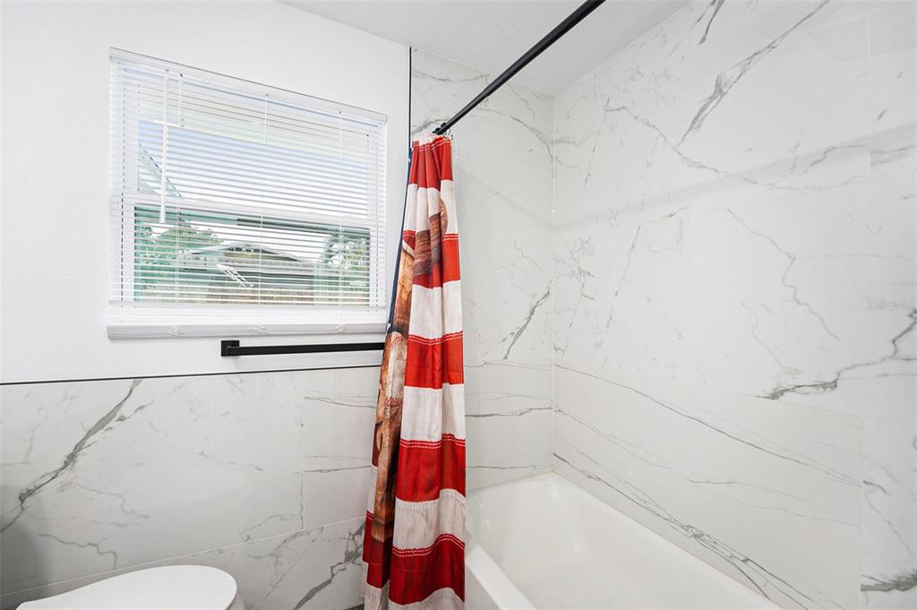 1806 North Keene Road Clearwater, FL 33755 - Photo 21 of 35 a bathroom with a shower and a toilet