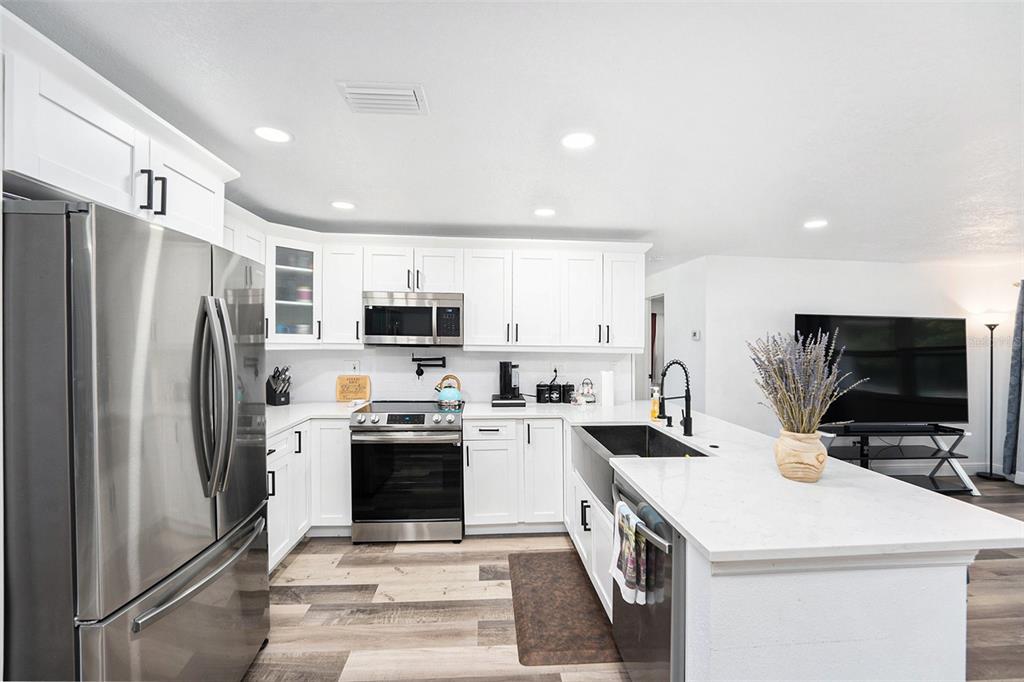 1806 North Keene Road Clearwater, FL 33755 - Photo 6 of 35 a kitchen with stainless steel appliances a stove a sink a refrigerator a stove top oven and cabinets