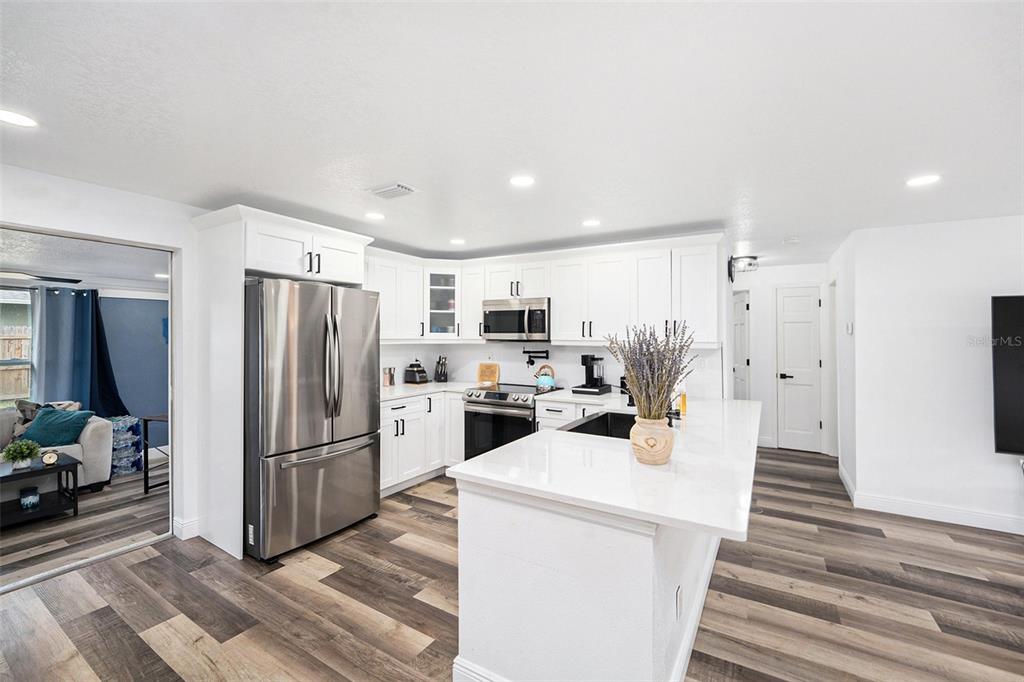 1806 North Keene Road Clearwater, FL 33755 - Photo 7 of 35 a kitchen with stainless steel appliances a refrigerator and a stove top oven