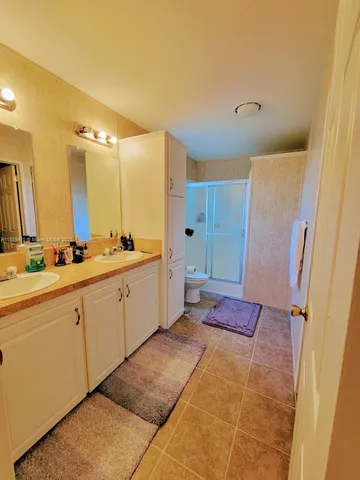 a spacious bathroom with a mirror sink and shower