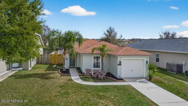 a view of a house with backyard and sitting area