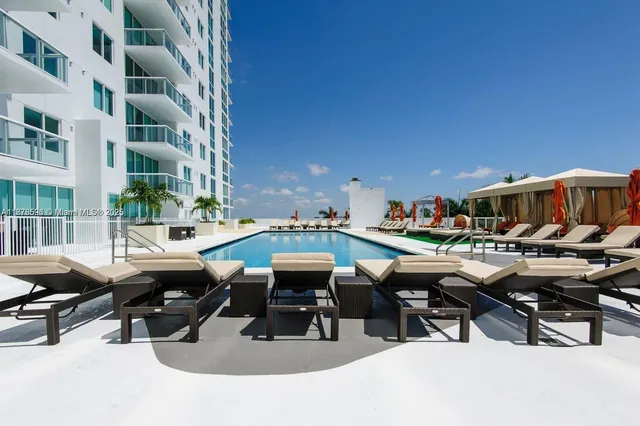 a view of a patio with table and chairs under an umbrella