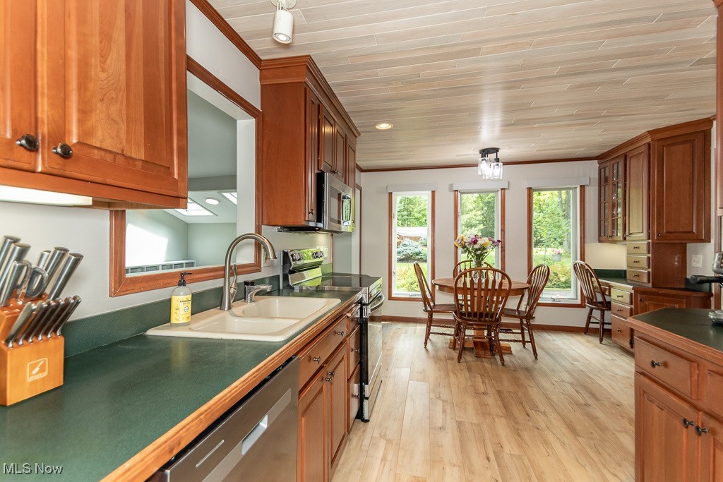 33 Woodside Road Chagrin Falls, OH 44022 - Photo 15 of 48 Kitchen featuring appliances with stainless steel finishes, light wood finished floors, wooden ceiling, brown cabinetry, and dark countertops