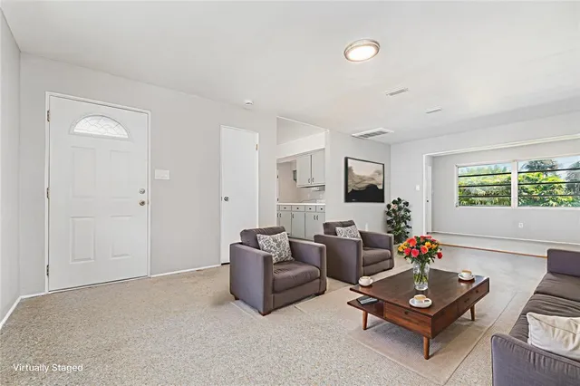 a living room with furniture a flat screen tv and a window