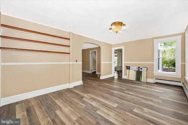 a kitchen with granite countertop a refrigerator oven a sink dishwasher and white cabinets with wooden floor