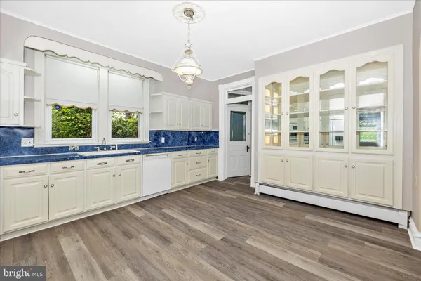 a kitchen with a refrigerator and white cabinets