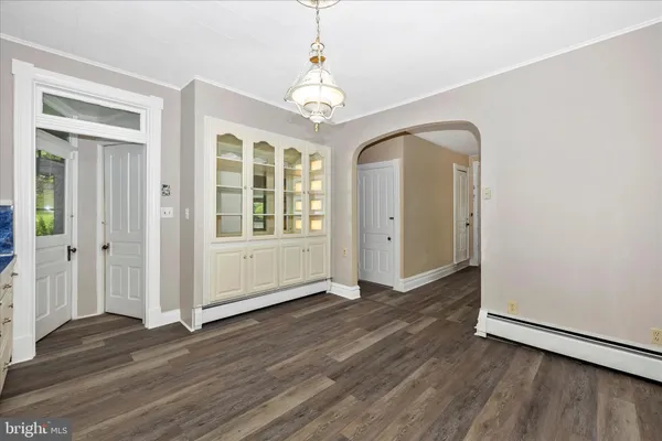 a kitchen that has a lot of cabinets in it and wooden floors