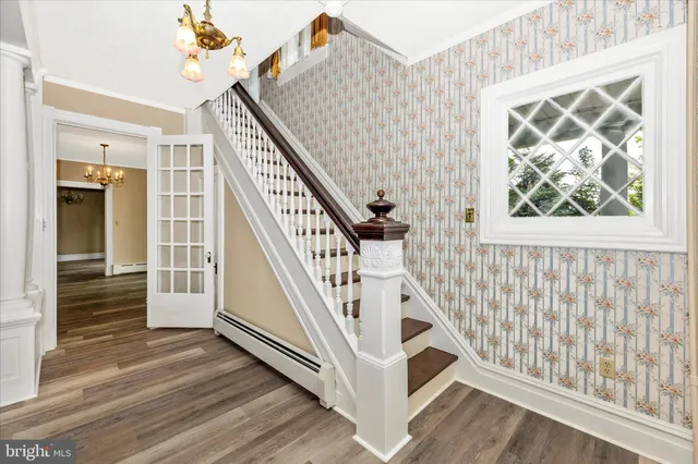 a view of an empty room with wooden floor fireplace and a window