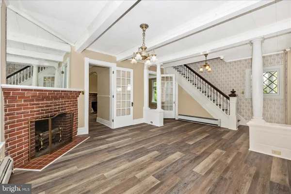 a view of an empty room with window and wooden floor