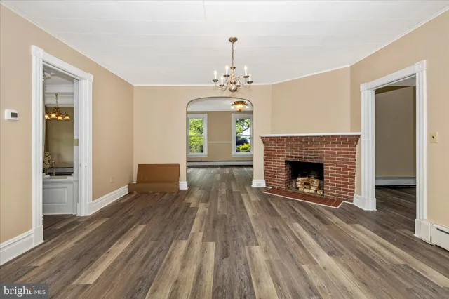 a large kitchen with granite countertop a stove a sink and white cabinets with wooden floor