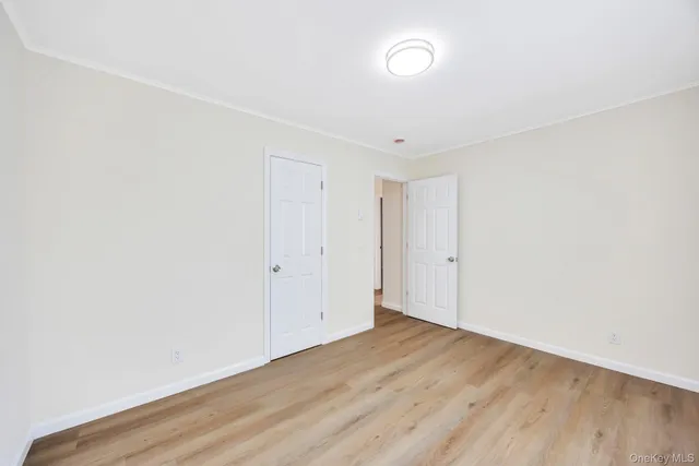 an empty room with wooden floor and white walls