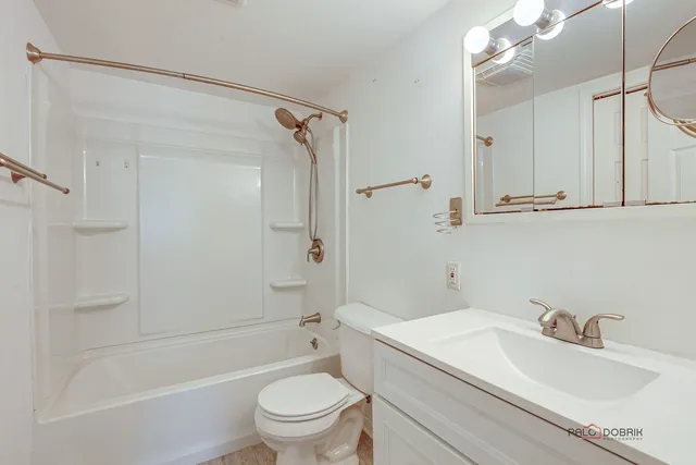 a bathroom with a sink toilet vanity and shower