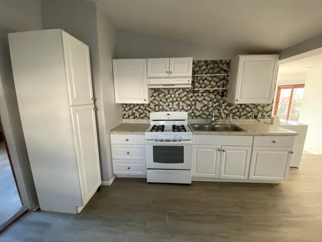 a kitchen with white cabinets and white appliances