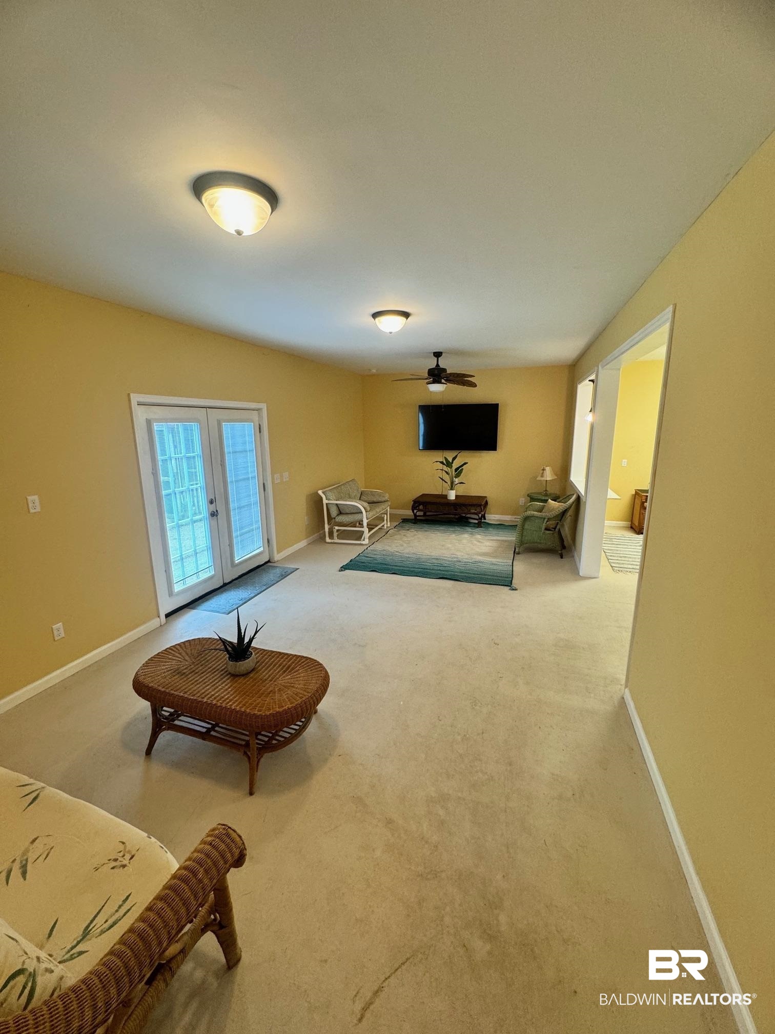 1985 Ridgewood Drive South Lillian, AL 36549 - Photo 12 of 40 Living area featuring french doors, ceiling fan, and carpet