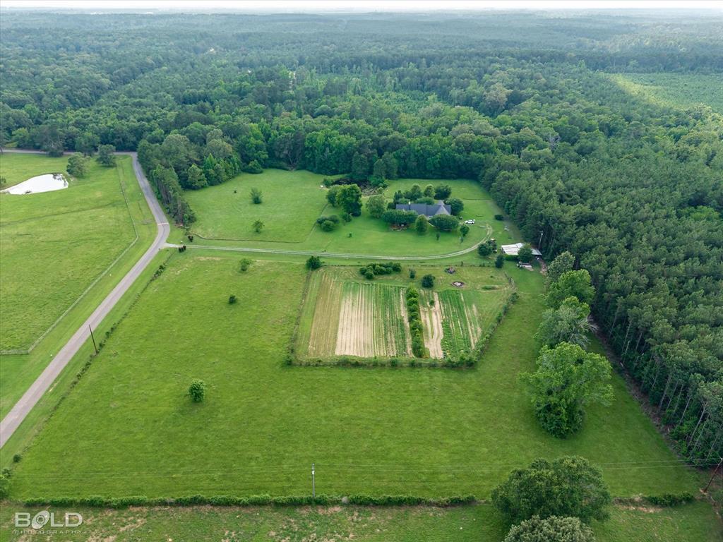 0 Twin Lakes Road Mansfield, LA 71052 - Photo 8 of 28 Expansive rural property featuring a primary residence with a dark roof, surrounded by extensive green lawns and mature trees