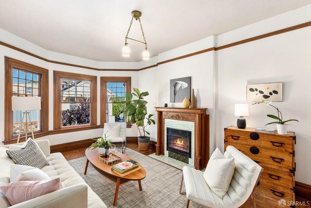 a living room with furniture fireplace and a large window