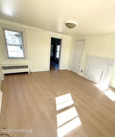 a view of a bedroom with wooden floor and windows
