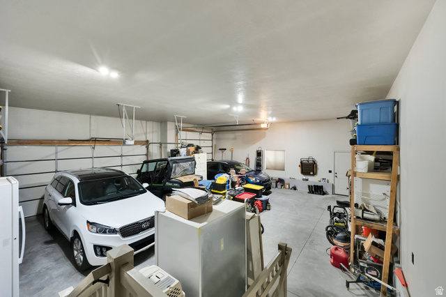 302 Old Farm Road Tooele, UT 84074 - Photo 18 of 30 Spacious garage with light grey walls, white ceiling, and concrete flooring