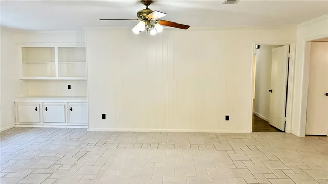 an empty room with closet and a chandelier fan