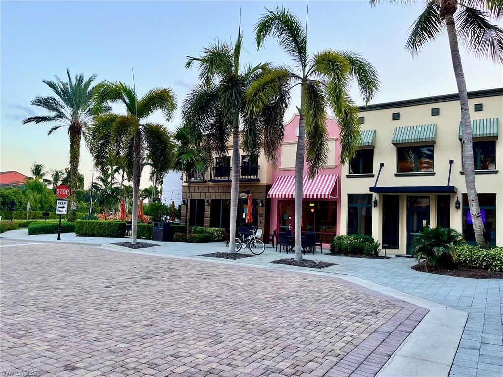 9126 Chula Vista Street, Unit 12301 Naples, FL 34113 - Photo 17 of 36 a front view of multi story residential apartment building with yard and green space