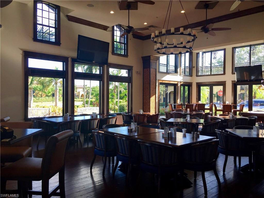9126 Chula Vista Street, Unit 12301 Naples, FL 34113 - Photo 20 of 36 a view of a dining room with furniture a chandelier and wooden floor