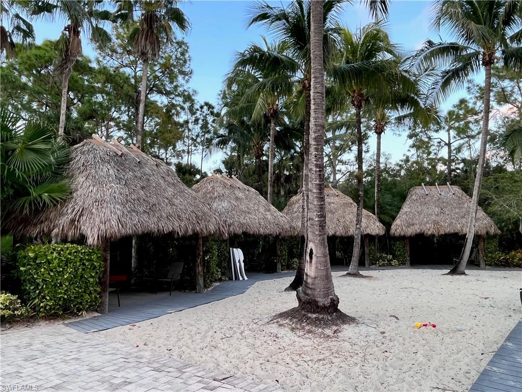 9126 Chula Vista Street, Unit 12301 Naples, FL 34113 - Photo 27 of 36 a front view of a house with yard and trees